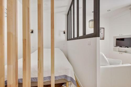 - une chambre avec des murs blancs et un lit avec un miroir dans l'établissement 4-Star Apartment for 4, 10 mn from Champs-Élysées, à Paris