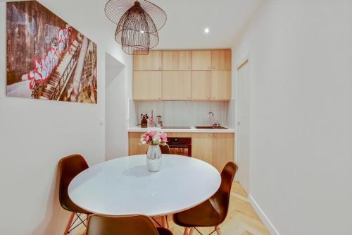 - une cuisine avec une table et des chaises blanches dans l'établissement 4-Star Apartment for 4, 10 mn from Champs-Élysées, à Paris