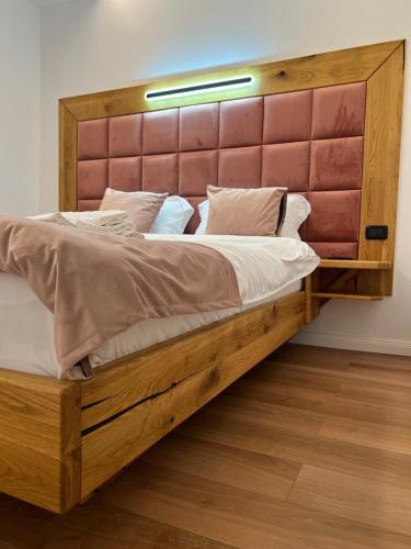 a large wooden bed with a large wooden headboard at Family Nest in Vărbilău