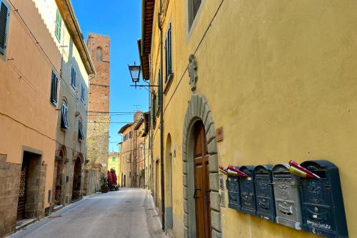 an alley with a yellow building and an empty street at Casa Colomba in Vicopisano