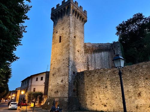 a large castle tower next to a wall at Casa Colomba in Vicopisano