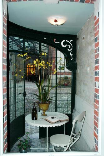 a table and a chair and a vase with flowers at Hotel Castel Jeanson in Ay