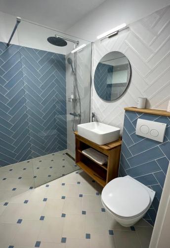 a bathroom with a toilet and a sink and a shower at Family Nest in Vărbilău