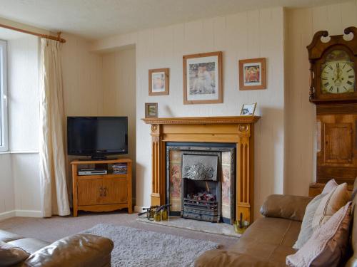 een woonkamer met open haard en tv bij Thurston View in Coniston