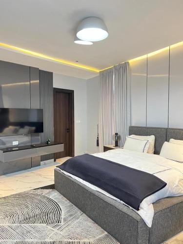 a bedroom with a large bed and a television at Luxury 2Bedroom Apartment with City View Victoria Island in Lagos