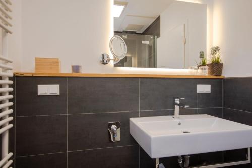 a bathroom with a white sink and a mirror at Südstrandquartier - Ferienwohnung Cor in Ostseebad Sellin