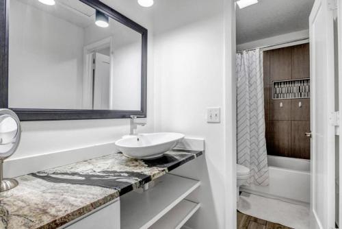 a white bathroom with a sink and a mirror at Bermuda Bungalow in Ponte Vedra Beach