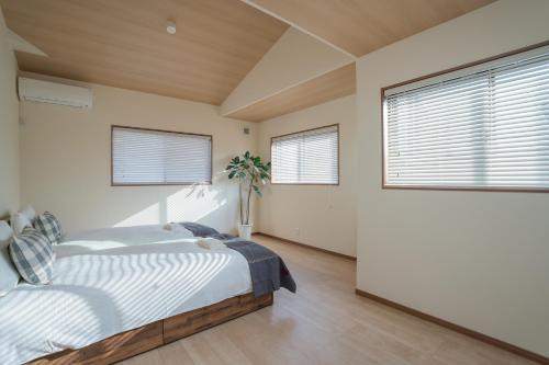 a bedroom with a bed and two windows at The Peony Hotel Kyoto in Kyoto