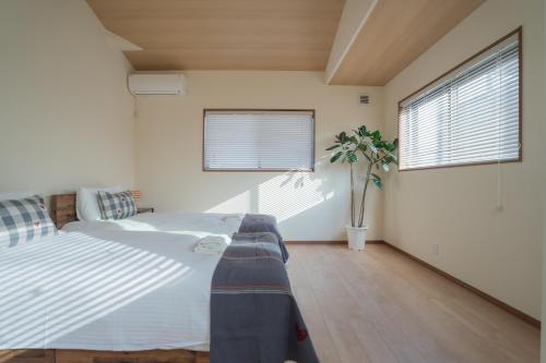 a bedroom with a large bed and two windows at The Peony Hotel Kyoto in Kyoto