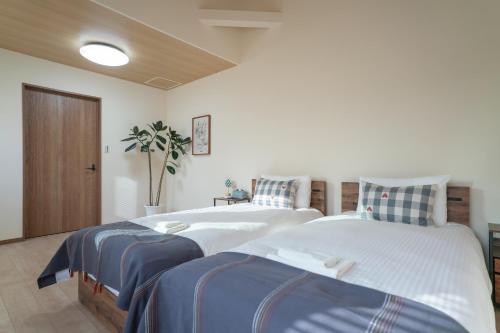 two twin beds in a room with at The Peony Hotel Kyoto in Kyoto