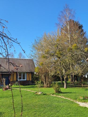 a house with a yard with green grass and trees at La petite maison in Le Bosc-Roger-en-Roumois