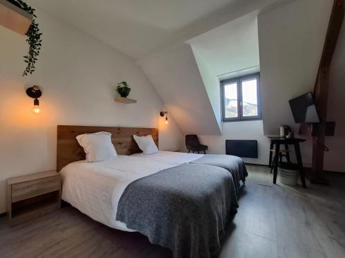 a bedroom with a large bed and a window at Le Permayou in Accous