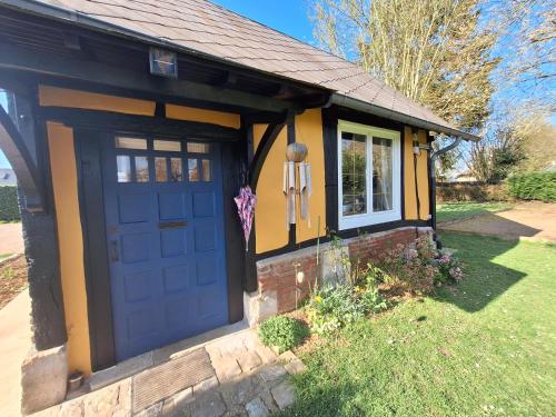 a small yellow house with a blue door at La petite maison in Le Bosc-Roger-en-Roumois