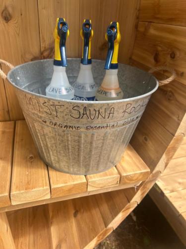 three rubber ducks in a metal bucket on a wooden table at Haida Gwaii Glamping in Tlell