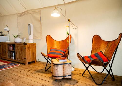 two chairs and a table in a living room at Haida Gwaii Glamping in Tlell