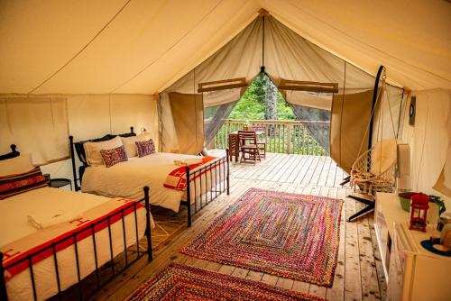 a tent bedroom with two beds and a patio at Haida Gwaii Glamping in Tlell