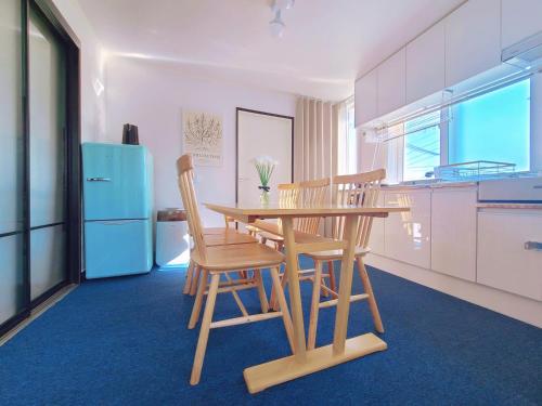 a kitchen with a wooden table and chairs and a blue refrigerator at 상왕십리역3분#미니영화관#층전체#동대문#명동#홍대#종로#성수#서울숲#한양대#청계천#공항버스 in Seoul
