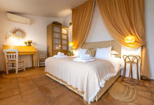 a bedroom with a large white bed and a desk at Romantic Ronda garden cottage in Ronda