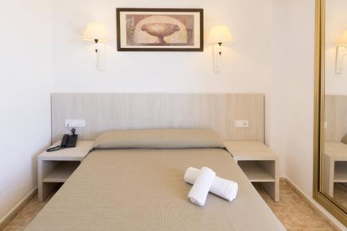 a bedroom with a bed with two towels on it at HSM Canarios Park in Calas de Mallorca