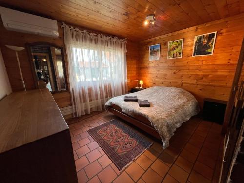 ein Schlafzimmer mit einem Bett in einer Holzhütte in der Unterkunft Albert Ranch House - Grande maison au calme - Parking in Ribeauvillé