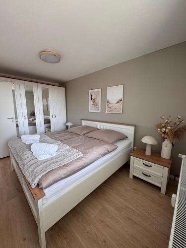 a bedroom with a large bed and a table at Fewo Strandbrise in Eckernförde