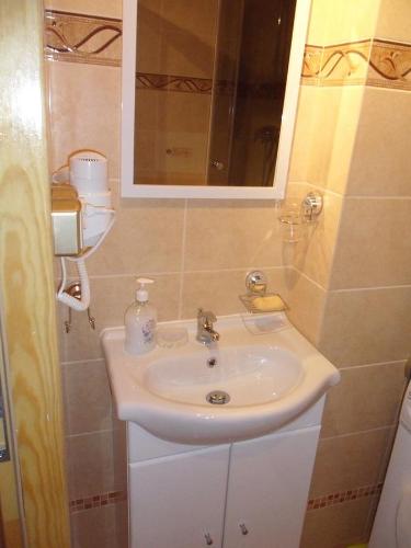a bathroom with a white sink and a mirror at Apartament Widokowy in Wrocław