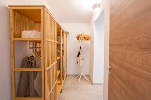 a walk in closet with a wooden door at Enotria Villas - Tramonto sullo Stromboli in Capo Vaticano