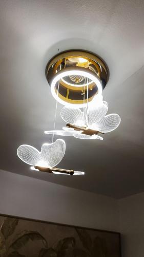 a chandelier with two butterflies hanging from a ceiling at Isha's Place Self Check-In 2BR Netflix WiFi Camella Homes Villakananga in Butuan