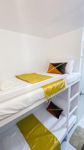 two bunk beds in a room with yellow sheets at Isha's Place Self Check-In 2BR Netflix WiFi Camella Homes Villakananga in Butuan