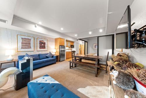a living room with a blue couch and a table at Palisades Tahoe Lodge Rentals Studio #110 in Olympic Valley