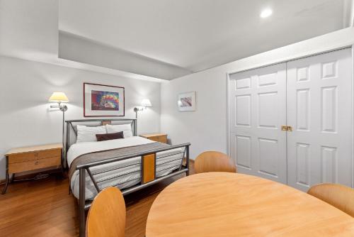 a bedroom with a bed and a table with chairs at Palisades Tahoe Lodge Rentals Studio #109 in Olympic Valley