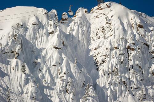 a mountain covered in snow with a ski lift at Palisades Tahoe Lodge Rentals Studio #109 in Olympic Valley