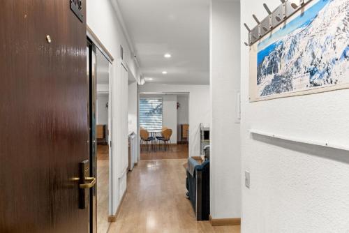 a hallway with a door and a room with a mountain painting at Palisades Tahoe Lodge Rentals Studio #109 in Olympic Valley