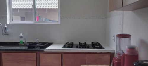 a kitchen with a stove and a sink and a window at Casa ideal 5 quatros sendo 3 suítes 2 km do centro in Bananeiras