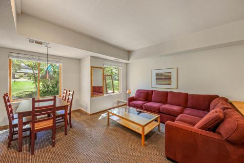 a living room with a red couch and a table at Palisades Tahoe Lodge Rentals Studio #104 in Olympic Valley