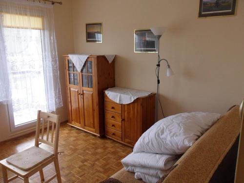 1 dormitorio con cama, silla y vestidor en Apartament Widokowy, en Wroclaw