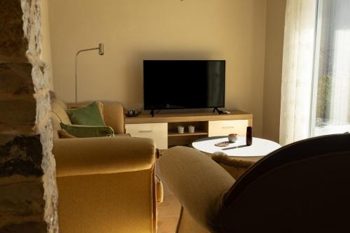a living room with two chairs and a flat screen tv at Villa Bregasi in Durrës