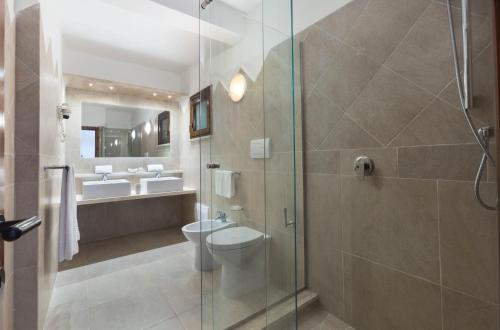 a bathroom with a toilet and a glass shower at Residence Il Mirto in Palau