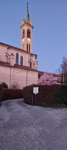 a church with a tower with a clock on it at Oryza Guest House in Desana