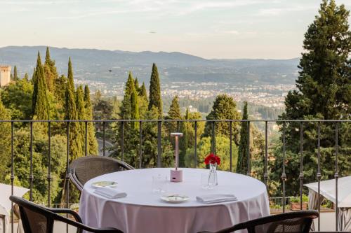 a white table with chairs and a view of a city at FH55 Hotel Villa Fiesole in Fiesole