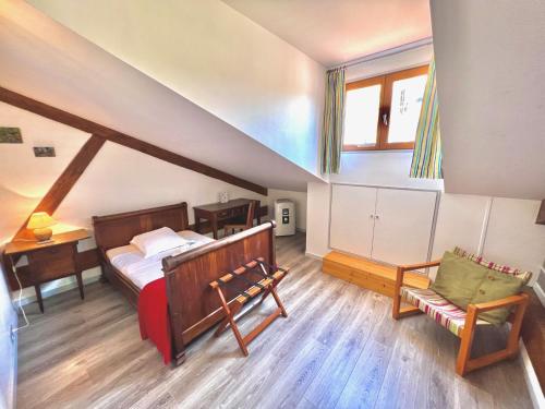 Cette chambre mansardée comprend un lit et une chaise. dans l'établissement E OP Duplex d Antoine Old Port - Old Town, à Nice