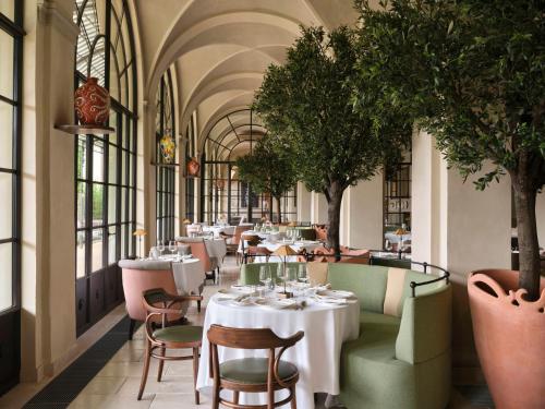 a restaurant with tables and chairs and trees at Collegio alla Querce, Auberge Collection in Florence