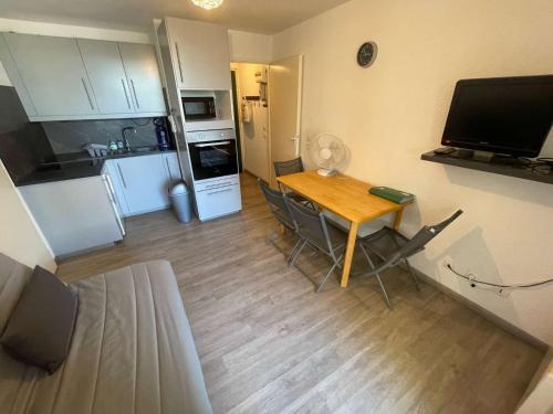 une petite cuisine avec une table et des chaises dans une pièce dans l'établissement Appartement climatisé avec 1 chambre à deux pas de la plage des Sablettes, à La Seyne-sur-Mer