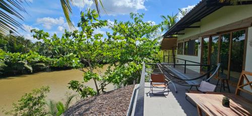 a balcony of a house with a river at InnerZen Riverside homestay Ben Tre - Japanese style in Ấp Phú Hòa (3)