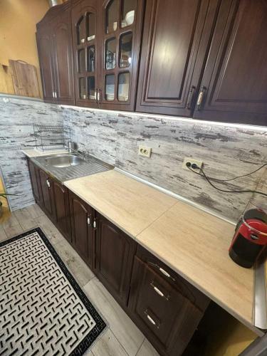 a kitchen with a counter and a sink and wooden cabinets at Marta's apartment in Shabla