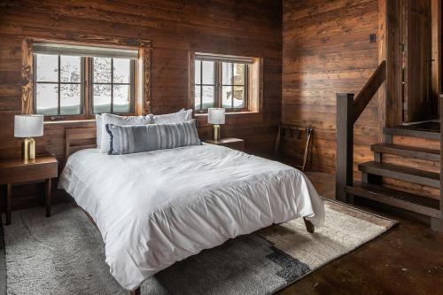 a bedroom with a large bed and two windows at Big Sky Fire Towers - Two Home Compound - Sleeps 16! in Big Sky