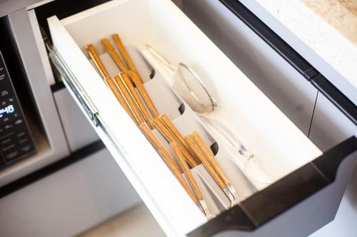 a drawer full of utensils in a microwave at Lille Cambui Studios Luxo by Robert Stays in Campinas