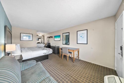 a hotel room with a bed and a desk at Executive Inn - Panama City Beach in Panama City Beach