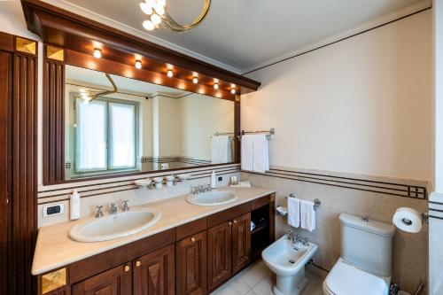 a bathroom with two sinks and a toilet and a mirror at Palazzo Porta Picta in Bergamo