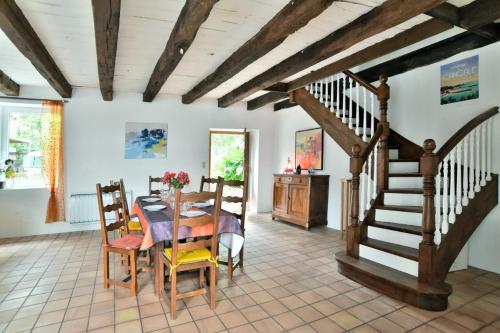une salle à manger avec une table et un escalier dans l'établissement Maison Kalisol, à Pleine-Fougères